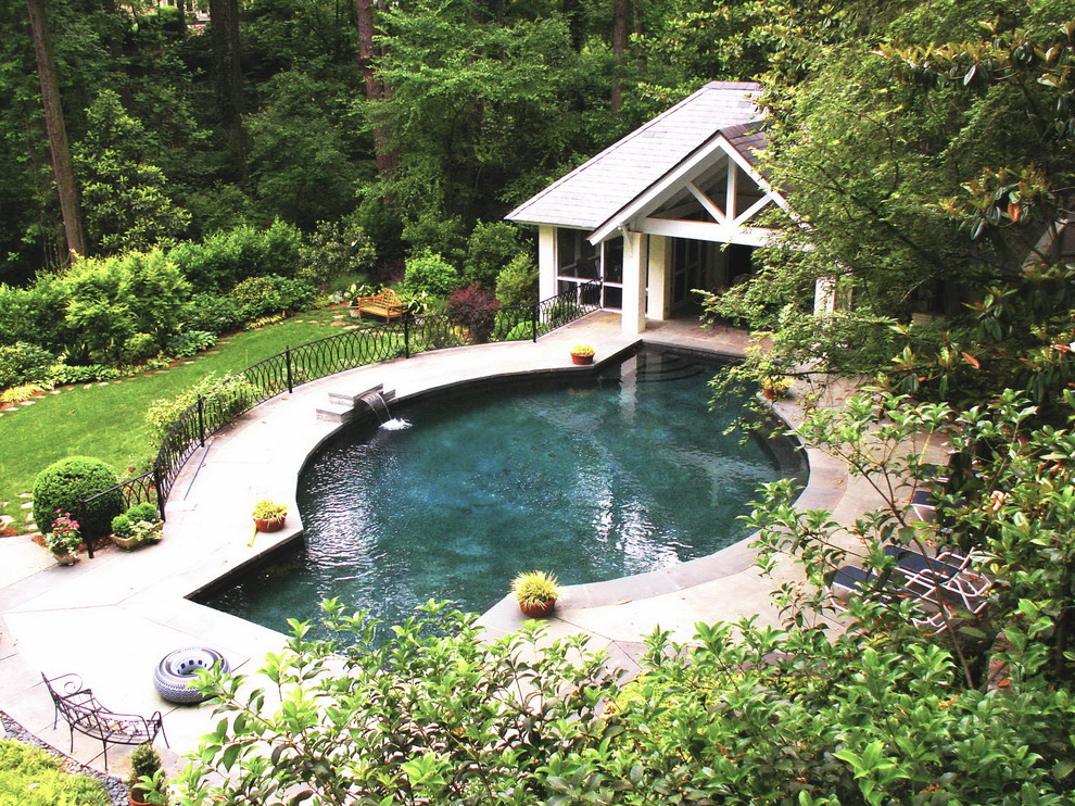 Пример оригинального дизайна: большой бассейн произвольной формы на заднем дворе в классическом стиле с домиком у бассейна и покрытием из бетонных плит