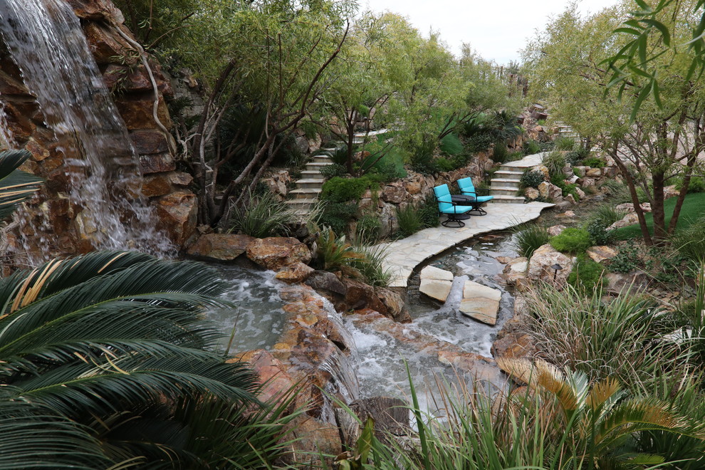 Modelo de piscina con fuente natural tropical extra grande a medida en patio trasero con adoquines de piedra natural