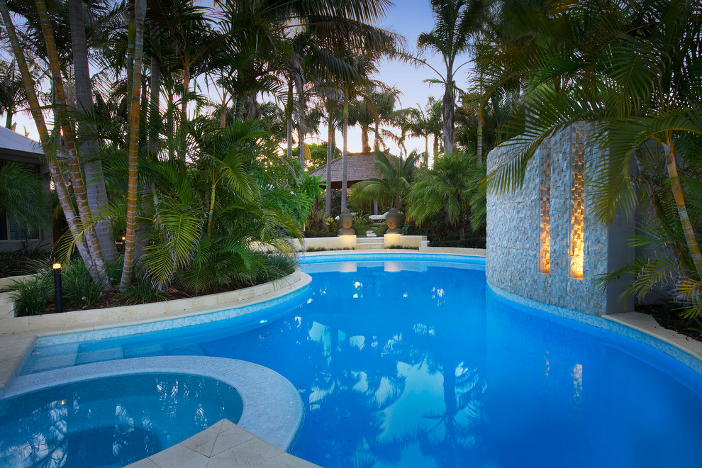 Foto på en stor tropisk pool på baksidan av huset