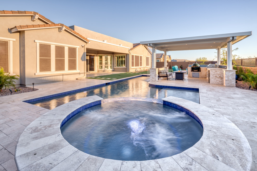 Large minimalist backyard concrete paver and rectangular natural pool fountain photo in Phoenix