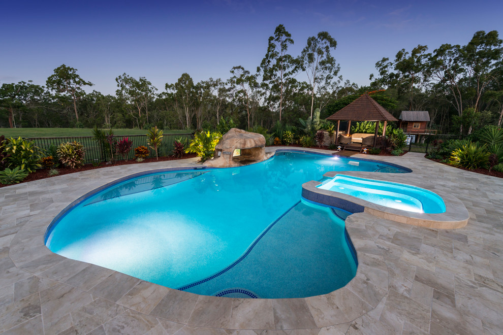 Immagine di una piscina tropicale personalizzata con una dépendance a bordo piscina