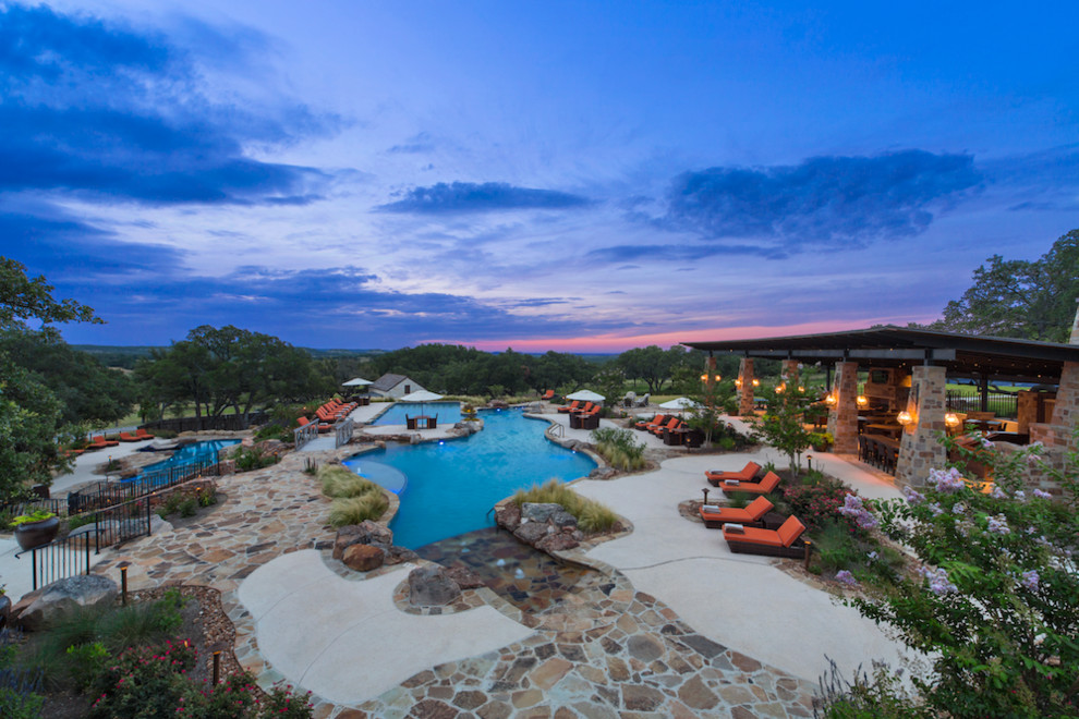 Huge mountain style backyard stone and custom-shaped pool photo in Austin