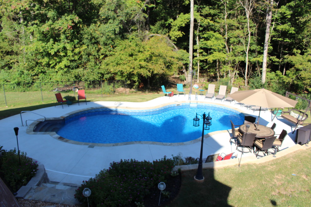 Foto de piscina tradicional de tamaño medio a medida en patio trasero