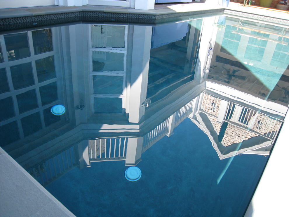 Cette image montre une grande piscine naturelle marine rectangle avec une cour et des pavés en béton.