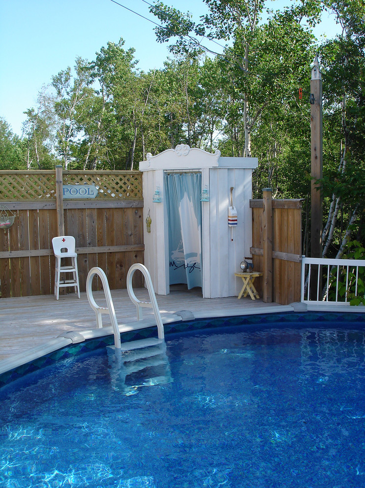 Nautical round swimming pool in Other with decking and a pool house.