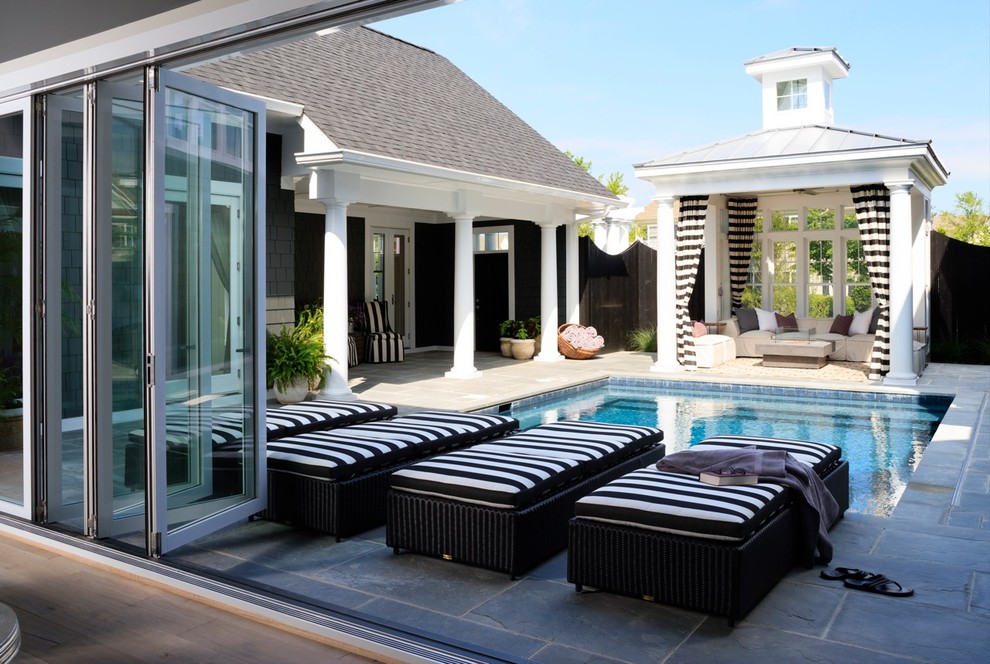 Esempio di una piscina stile marinaro rettangolare dietro casa con una dépendance a bordo piscina e pavimentazioni in pietra naturale