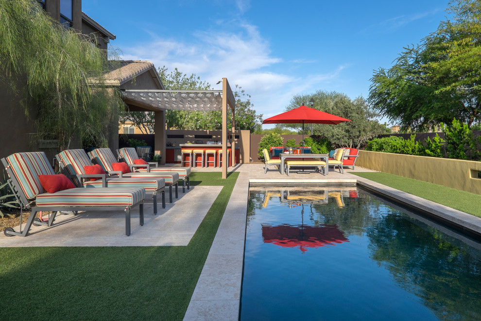 Diseño de piscina actual de tamaño medio rectangular en patio trasero con suelo de baldosas