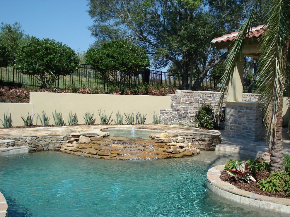 Idee per una piscina naturale classica personalizzata di medie dimensioni e dietro casa con una vasca idromassaggio e pavimentazioni in pietra naturale
