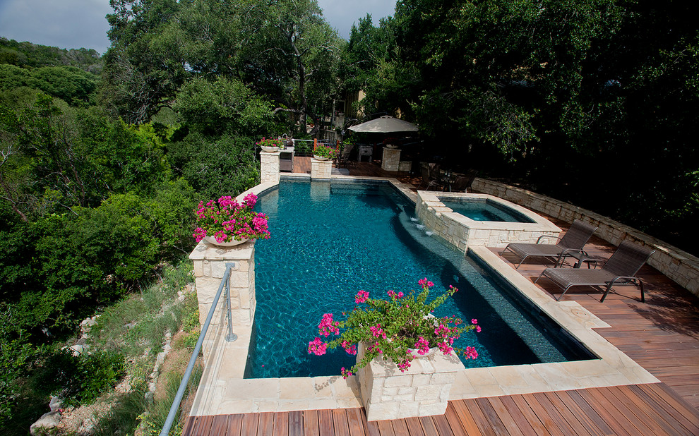 Exemple d'une piscine arrière et naturelle chic sur mesure et de taille moyenne avec une terrasse en bois et un bain bouillonnant.