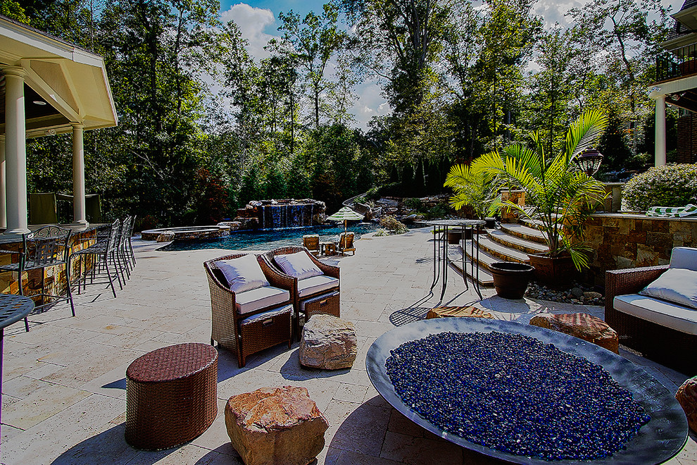 Idee per una grande piscina naturale eclettica personalizzata dietro casa con fontane e pavimentazioni in pietra naturale