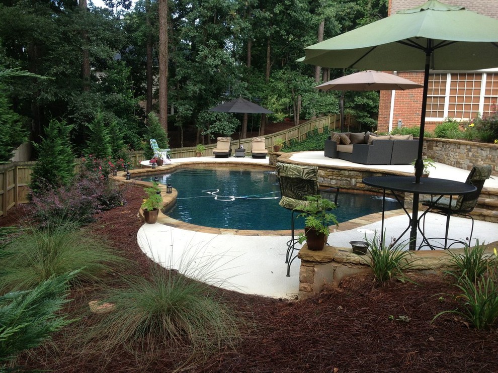 Inspiration for a mid-sized timeless backyard concrete and custom-shaped lap pool remodel in Atlanta