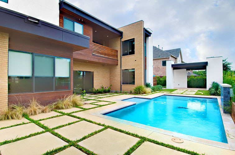 Foto de piscina con fuente natural moderna grande rectangular en patio trasero con adoquines de piedra natural