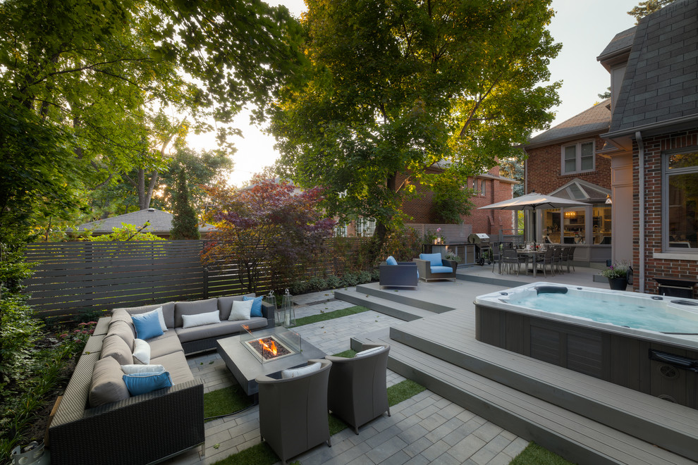 Idées déco pour une grande piscine hors-sol et arrière contemporaine rectangle avec un bain bouillonnant et une terrasse en bois.