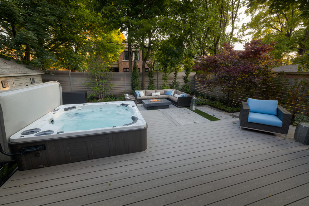 Стильный дизайн: большой наземный, прямоугольный бассейн на заднем дворе в современном стиле с джакузи и настилом - последний тренд