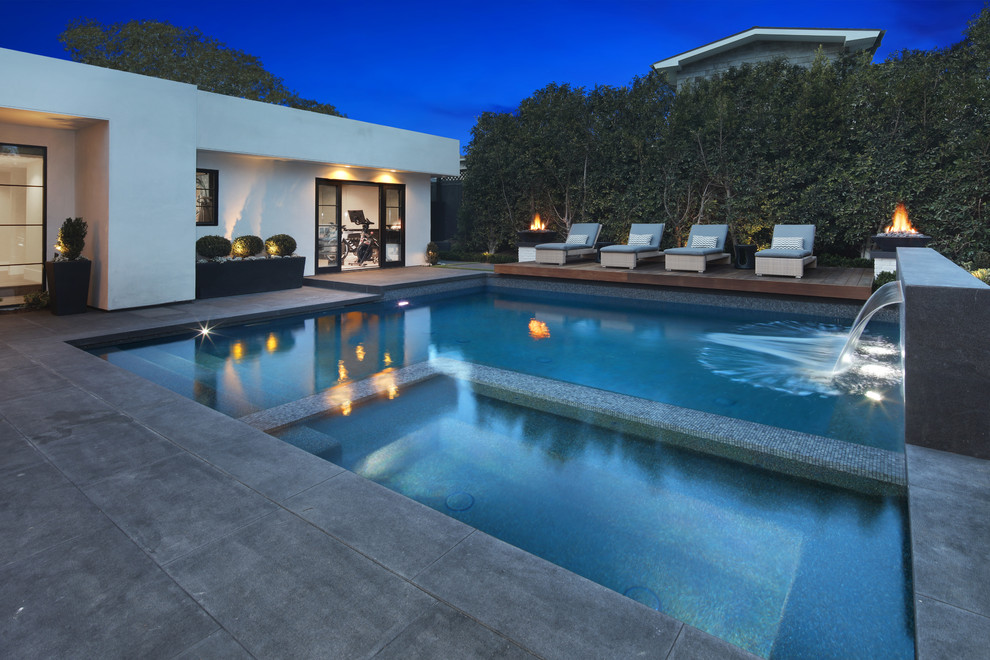 Idee per una piscina a sfioro infinito moderna rettangolare di medie dimensioni e dietro casa con una vasca idromassaggio e pavimentazioni in pietra naturale