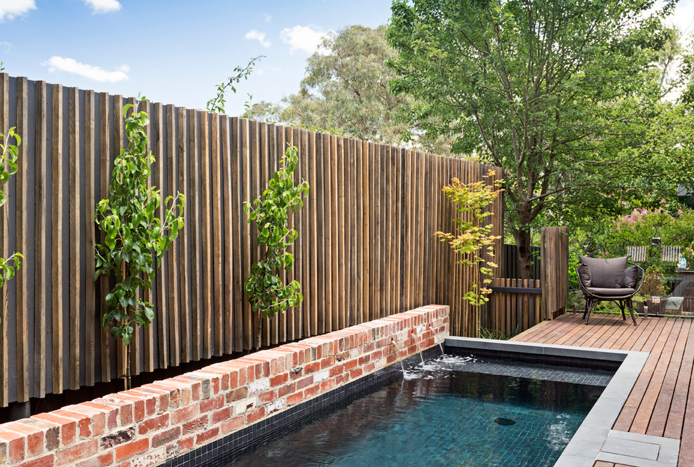 Réalisation d'une petite piscine hors-sol design rectangle avec un point d'eau, une cour et une terrasse en bois.