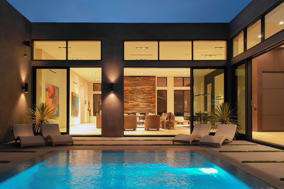 Ejemplo de piscinas y jacuzzis naturales contemporáneos de tamaño medio rectangulares en patio trasero con suelo de baldosas