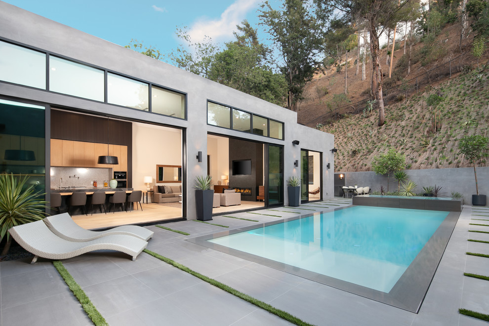 Пример оригинального дизайна: прямоугольный бассейн среднего размера на заднем дворе в современном стиле с джакузи и покрытием из плитки
