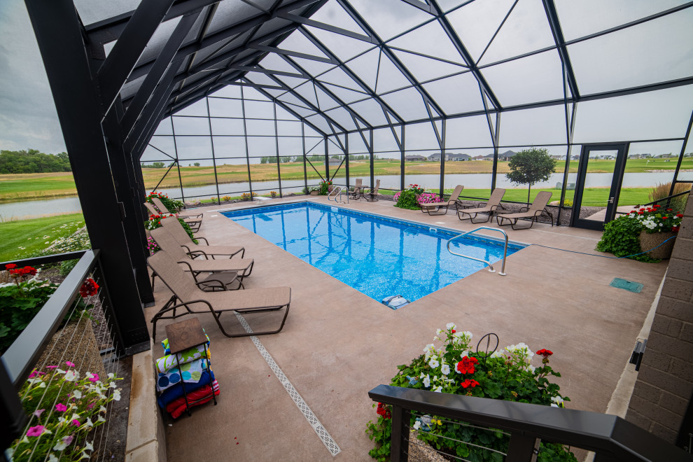 Foto di una grande piscina monocorsia minimal rettangolare dietro casa con paesaggistica bordo piscina e lastre di cemento