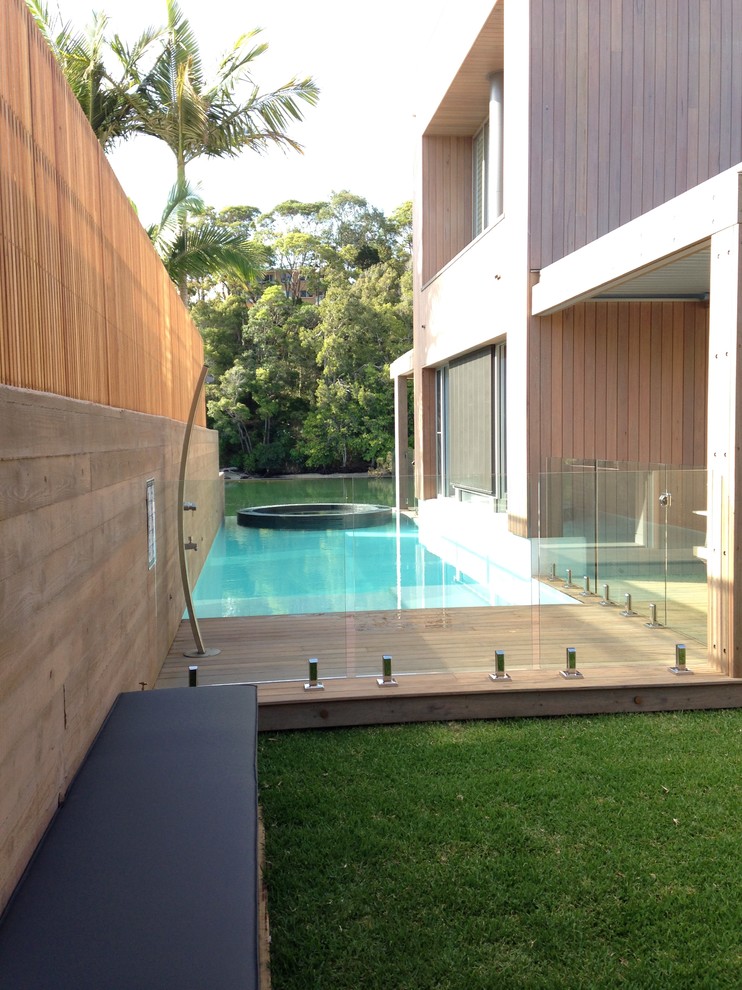 Modelo de casa de la piscina y piscina alargada marinera rectangular en patio lateral con suelo de baldosas