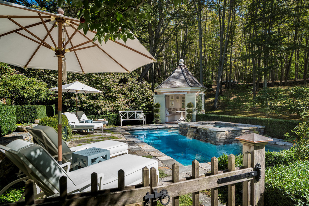 Imagen de piscinas y jacuzzis alargados tradicionales rectangulares en patio trasero con adoquines de piedra natural
