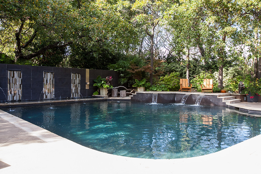 Großer Moderner Schwimmteich hinter dem Haus in individueller Form mit Wasserspiel und Betonplatten in Dallas