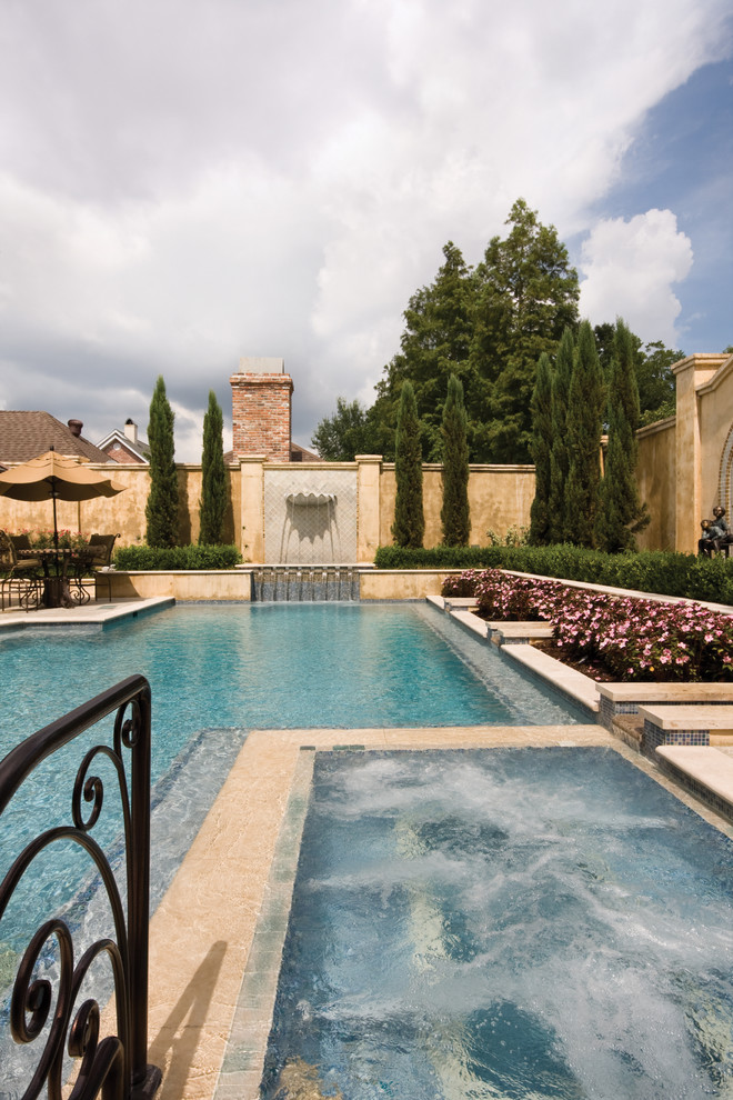 Esempio di una grande piscina monocorsia classica personalizzata dietro casa con una vasca idromassaggio e lastre di cemento