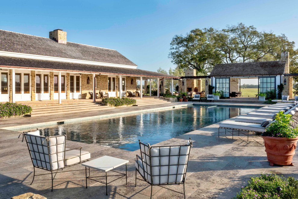 Country back rectangular swimming pool in Other with a pool house.