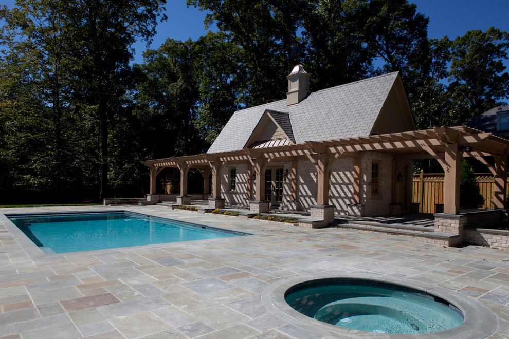 Réalisation d'un très grand Abris de piscine et pool houses arrière tradition rectangle avec des pavés en béton.