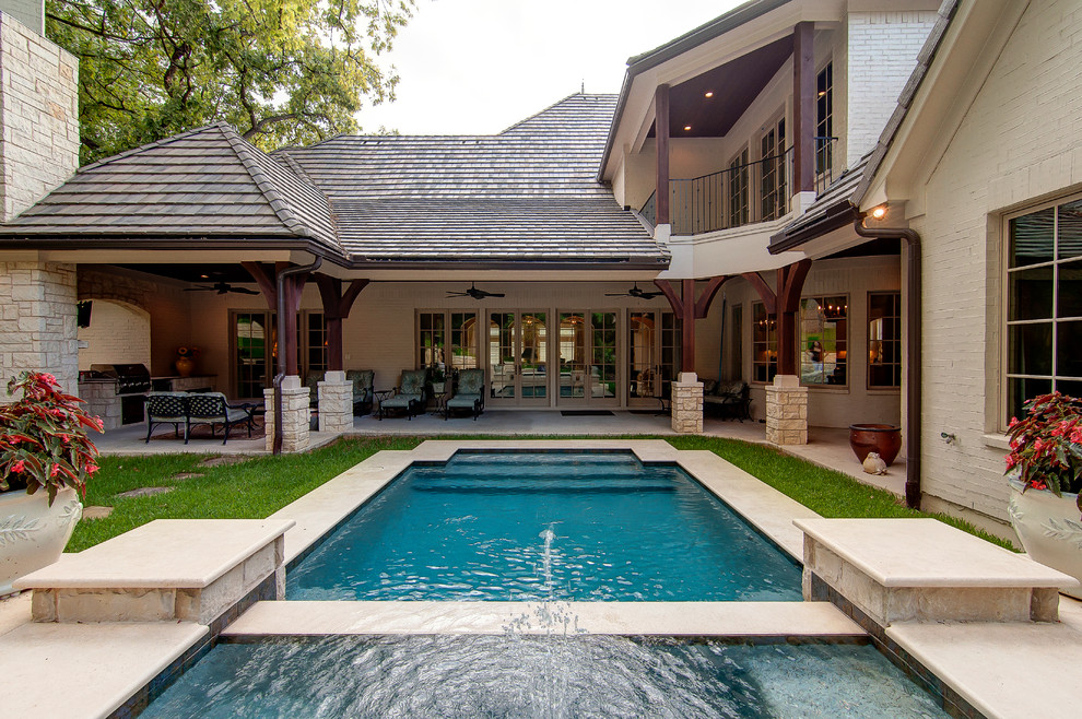 Elegant courtyard rectangular pool photo in Dallas