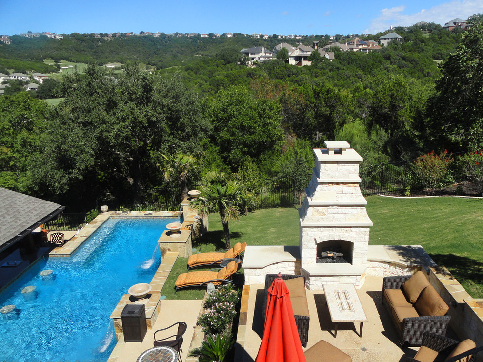 Großer Moderner Pool hinter dem Haus in rechteckiger Form mit Wasserspiel und Natursteinplatten in Austin