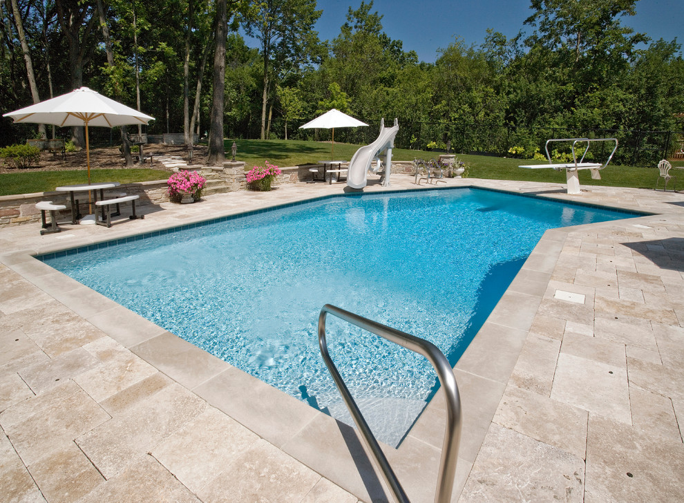 Foto de piscinas y jacuzzis alargados contemporáneos de tamaño medio a medida en patio trasero con adoquines de piedra natural