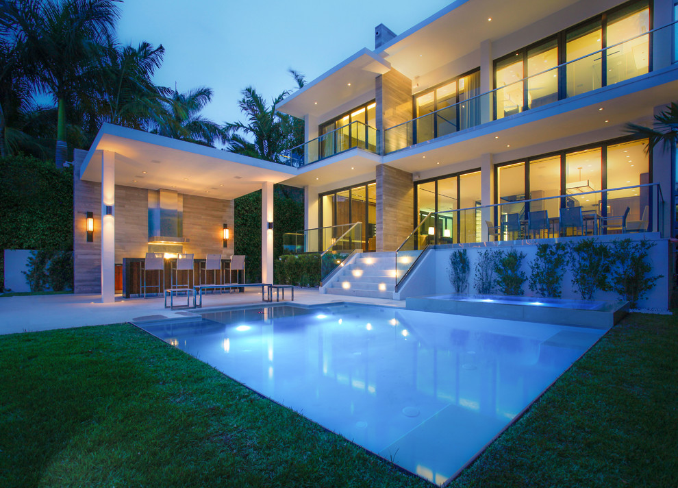 Immagine di una piscina a sfioro infinito moderna rettangolare di medie dimensioni e dietro casa con una dépendance a bordo piscina