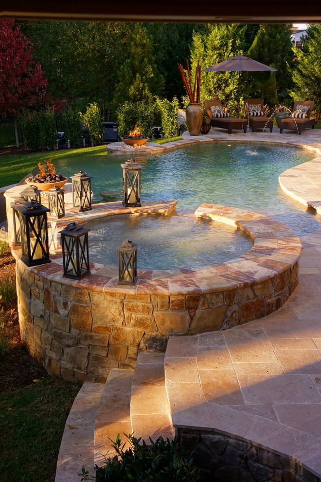 Diseño de piscinas y jacuzzis actuales a medida en patio trasero con adoquines de piedra natural