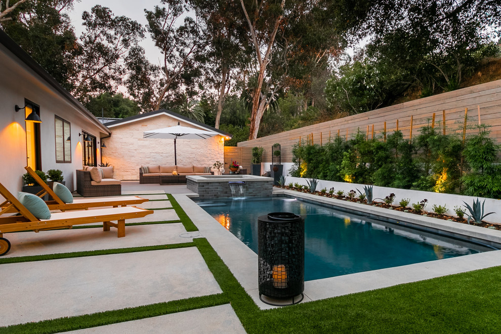 Foto de piscinas y jacuzzis alargados actuales rectangulares en patio trasero con losas de hormigón