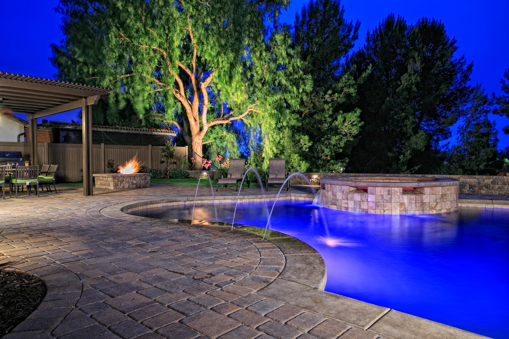 Пример оригинального дизайна: большой естественный бассейн произвольной формы на заднем дворе в классическом стиле с джакузи и мощением тротуарной плиткой