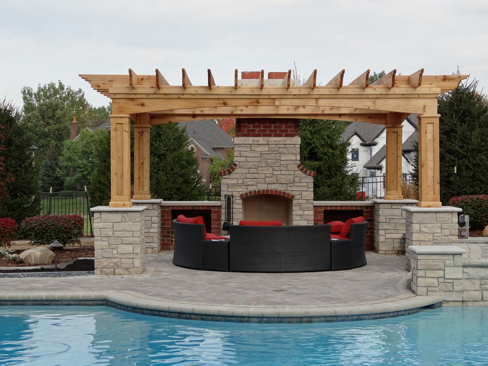Diseño de piscinas y jacuzzis naturales clásicos grandes a medida en patio trasero con adoquines de hormigón