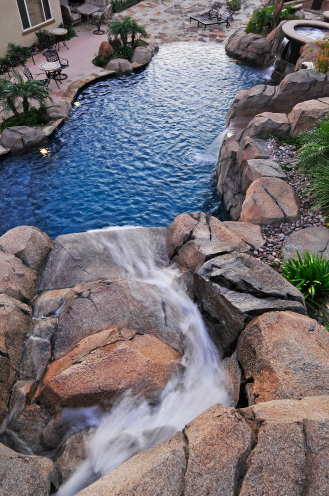 На фото: большой естественный бассейн произвольной формы на заднем дворе в морском стиле с джакузи и покрытием из бетонных плит