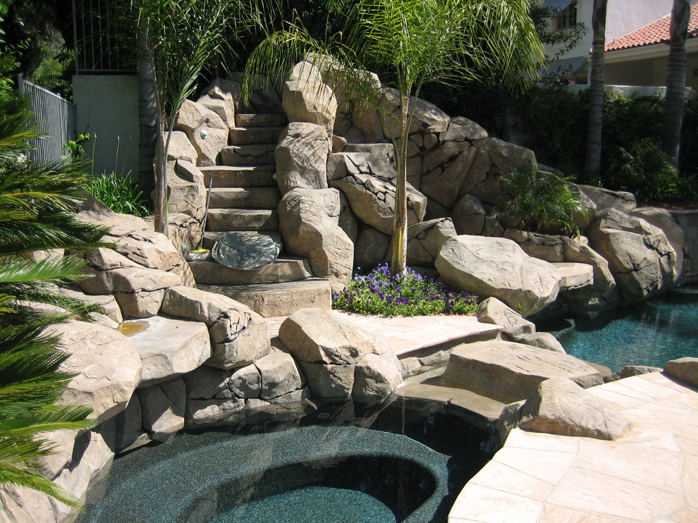 Design ideas for a medium sized rustic back custom shaped lengths hot tub in Orange County with natural stone paving.