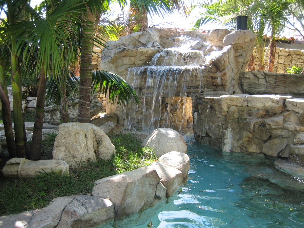 Photo of a large world-inspired back custom shaped swimming pool in Los Angeles with a water feature.
