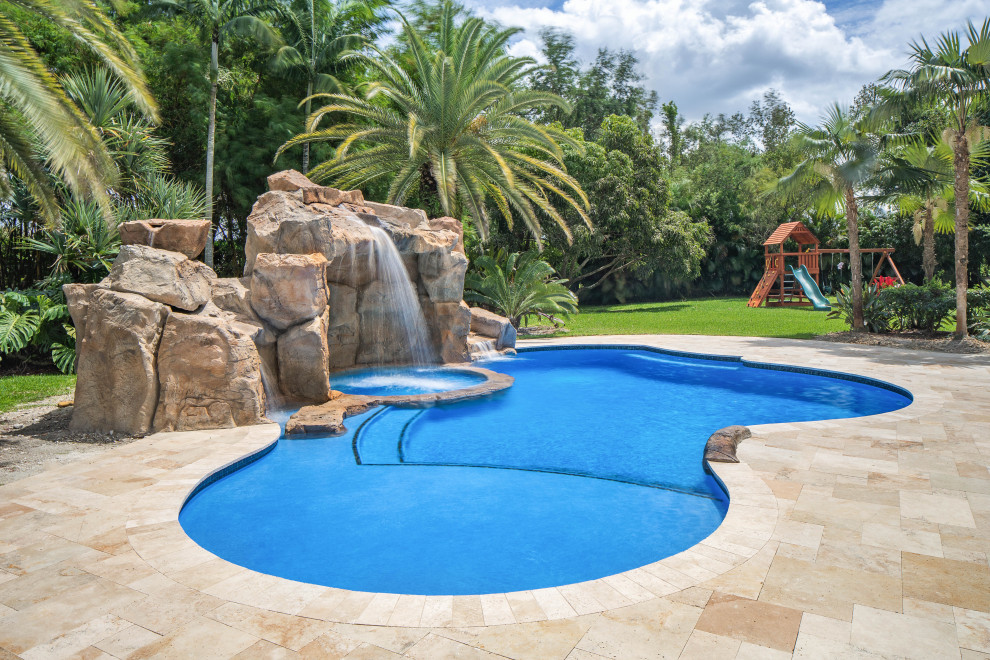 Idéer för stora tropiska anpassad pooler på baksidan av huset, med en fontän och naturstensplattor