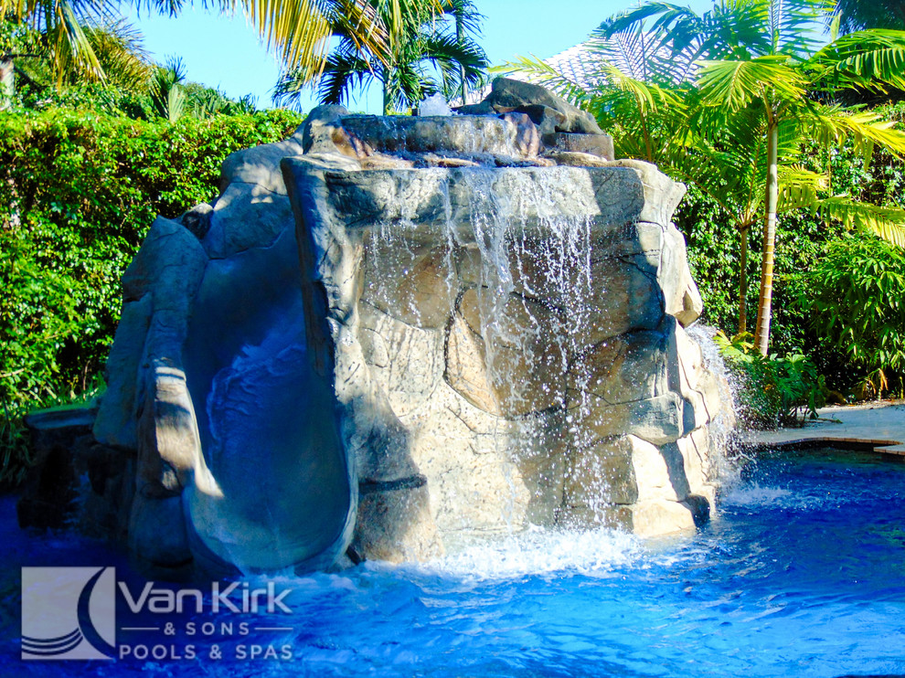 Imagen de piscina con fuente natural tropical extra grande a medida en patio trasero con adoquines de piedra natural