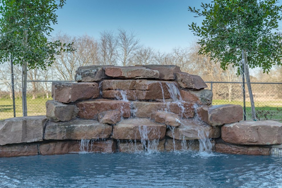 Réalisation d'une piscine naturelle et arrière chalet en forme de haricot de taille moyenne avec un bain bouillonnant et des pavés en pierre naturelle.
