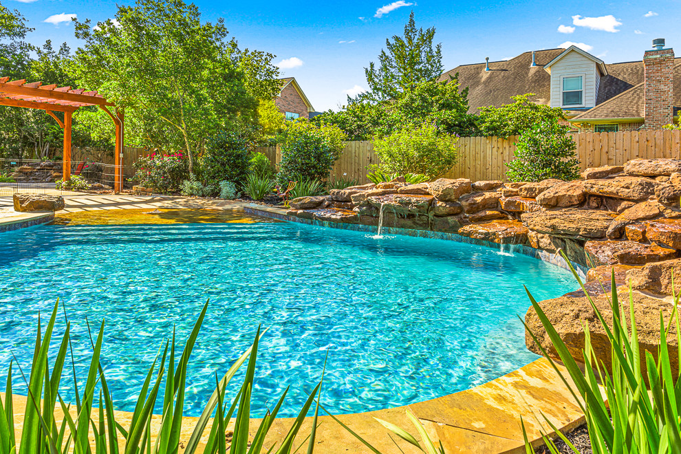 Example of a large island style side yard concrete and custom-shaped natural pool design in Other