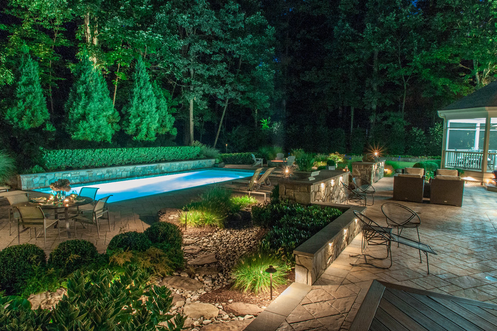 Imagen de piscina alargada bohemia de tamaño medio rectangular en patio trasero con adoquines de hormigón