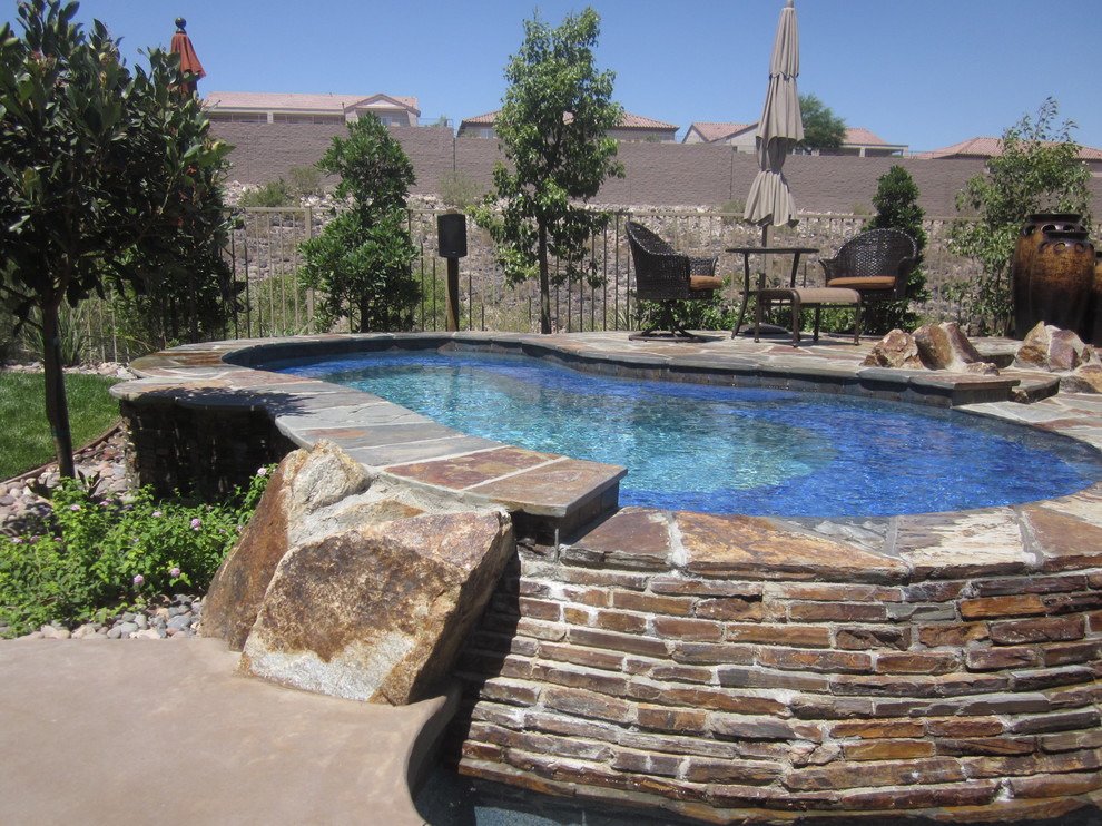 Immagine di una piscina naturale stile rurale personalizzata di medie dimensioni e dietro casa con fontane e pedane