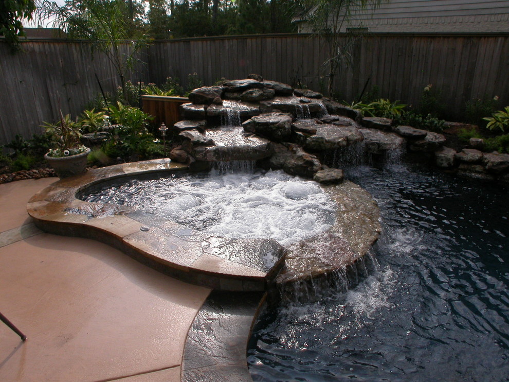 Large trendy backyard stone and custom-shaped natural hot tub photo in Houston