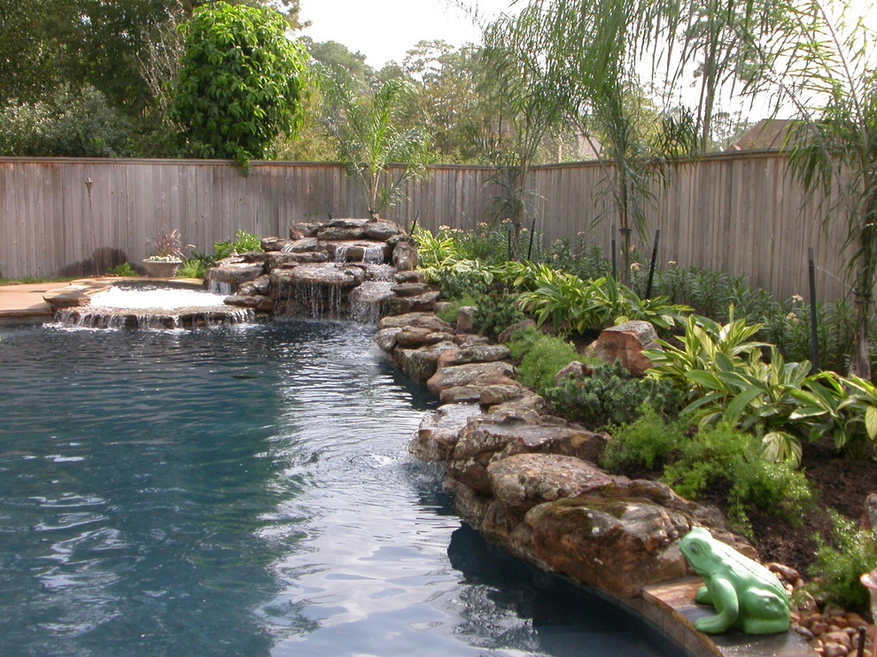 На фото: большой естественный бассейн произвольной формы на заднем дворе в современном стиле с фонтаном и покрытием из каменной брусчатки с