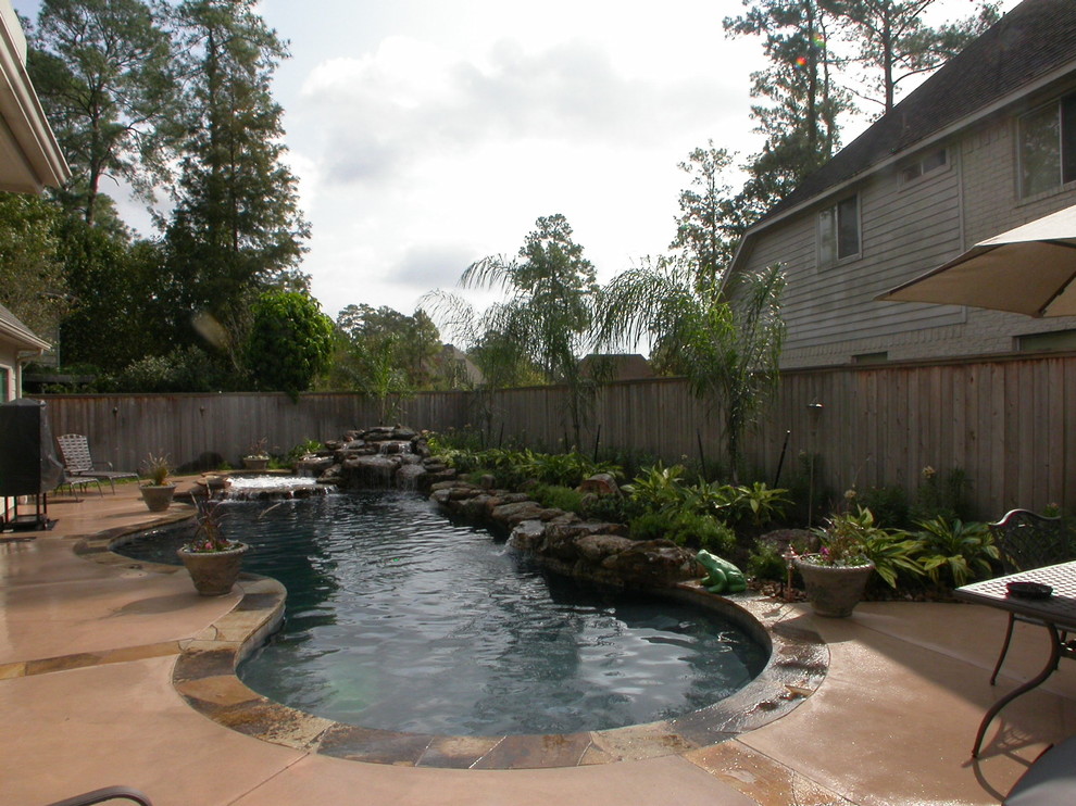 Ispirazione per una grande piscina naturale minimal personalizzata dietro casa con fontane e pavimentazioni in pietra naturale