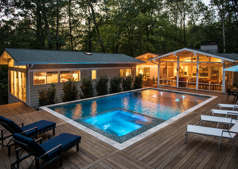 Réalisation d'une piscine latérale design rectangle avec un bain bouillonnant et une terrasse en bois.